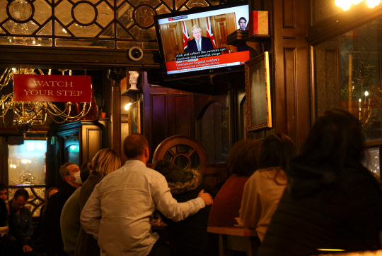 영국에서 코로나19 누적 확진자가 100만명을 넘어선 지난달 31일(현지시간) 런던의 한 펍에서 시민들이 TV를 통해 보리스 존슨 총리의 제2 봉쇄조치 도입 기자회견을 지켜보고 있다. 존슨 총리는 이날 회견에서 코로나19 재확산에 대응하기 위해 잉글랜드 전역에 4주간 봉쇄조치를 재도입한다고 발표했다.   연합뉴스